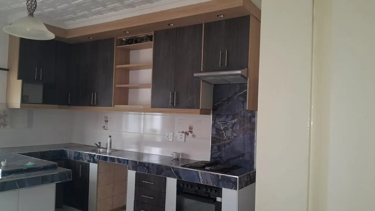 Two-tone oak and dark-oak kitchen with marble-look tops