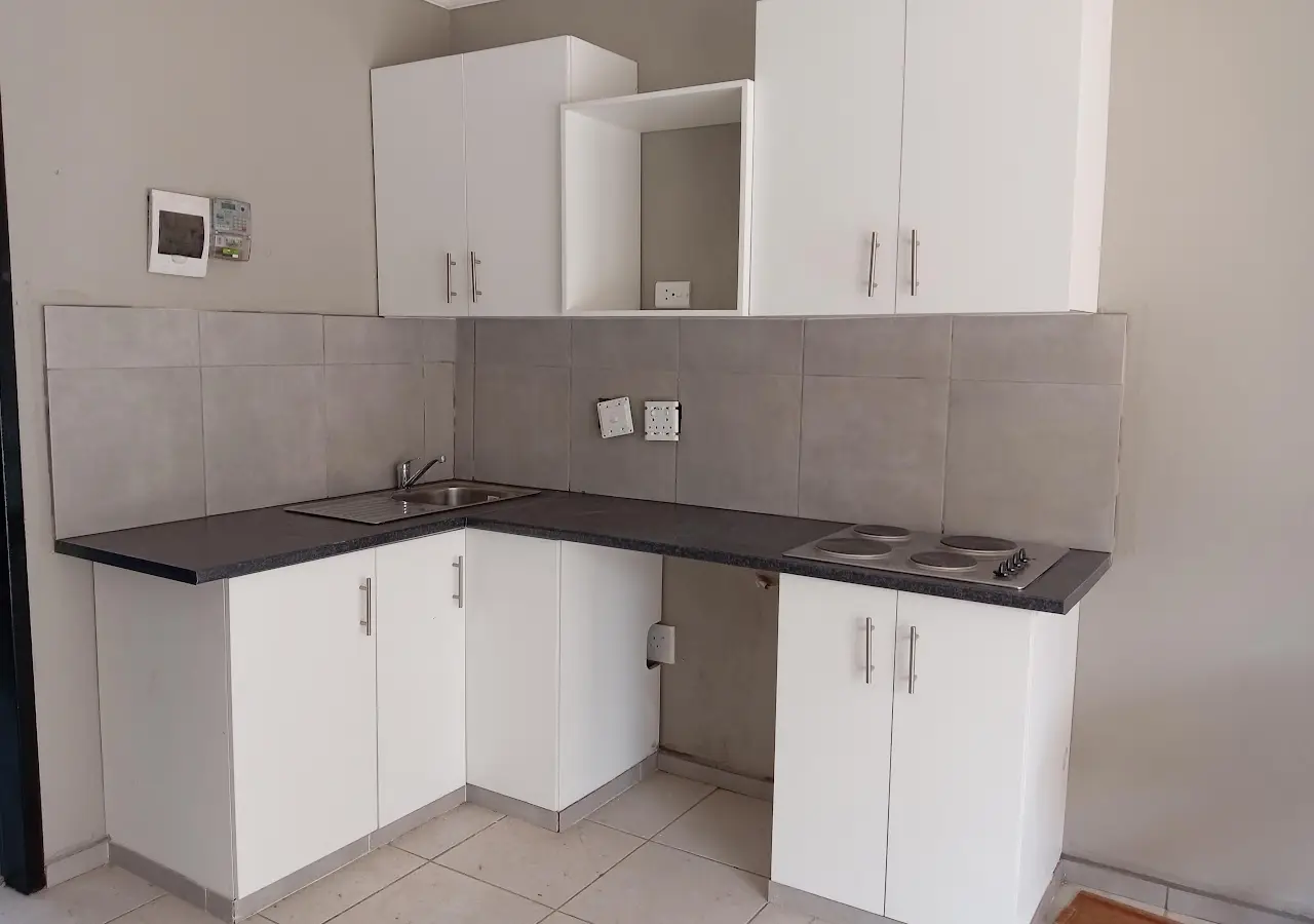 Fitted white kitchen with grey-tiled splashback