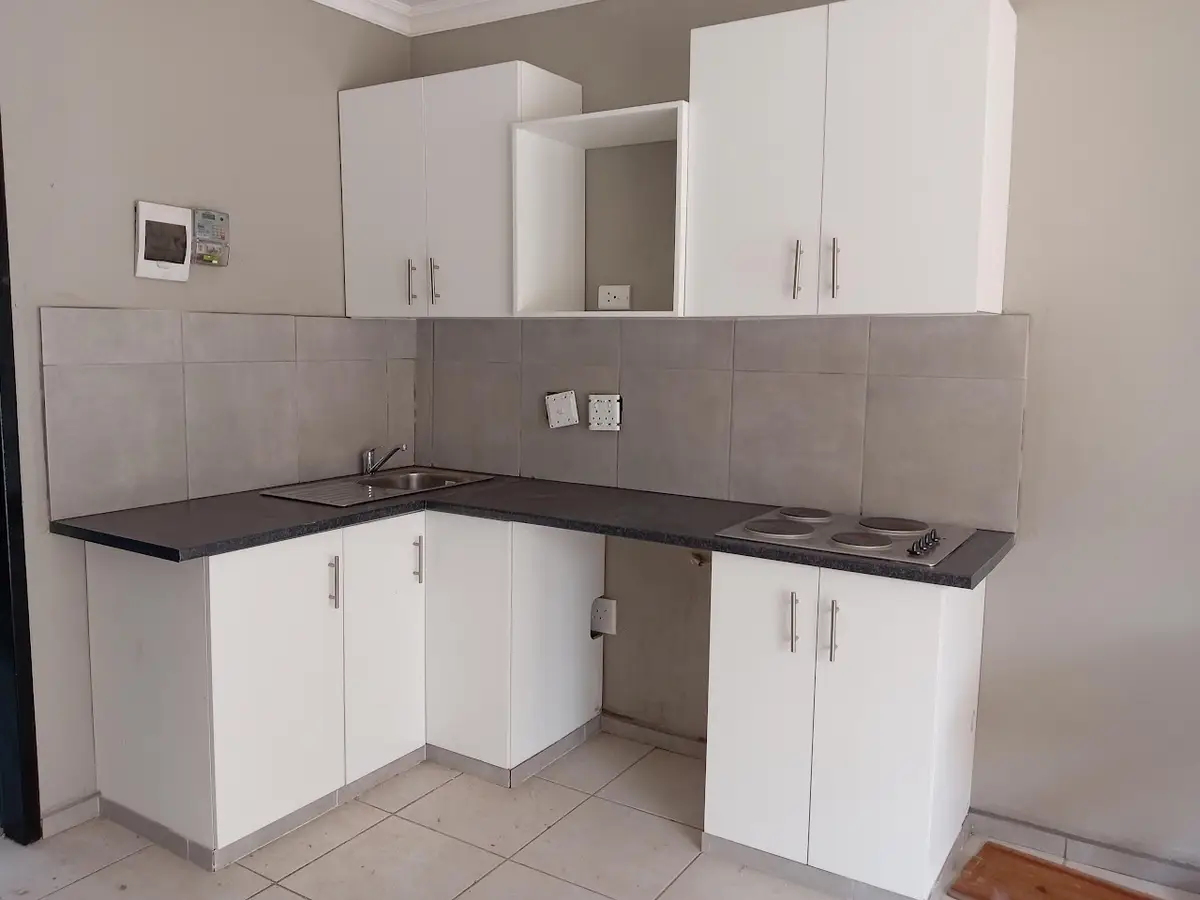 Fitted white kitchen with grey-tiled splashback