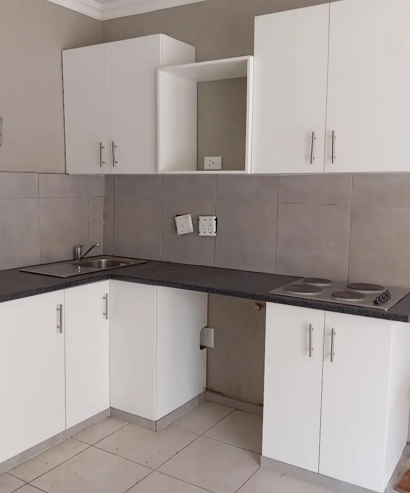 Fitted white kitchen with grey-tiled splashback