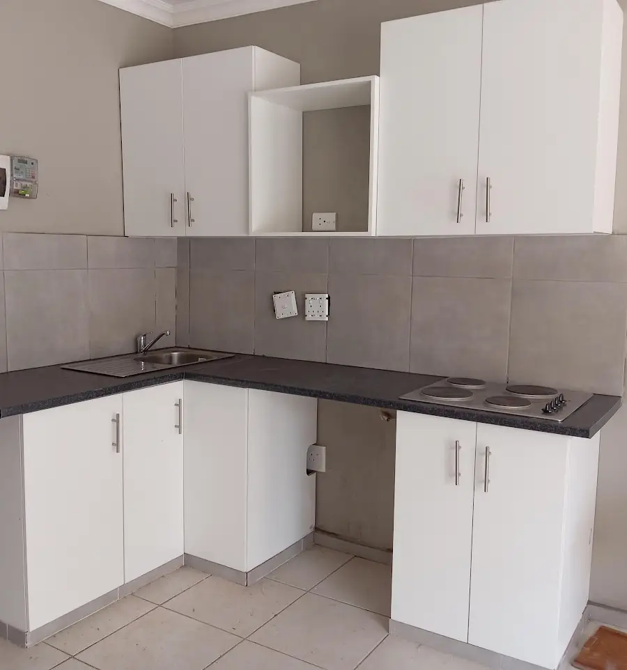 Fitted white kitchen with grey-tiled splashback