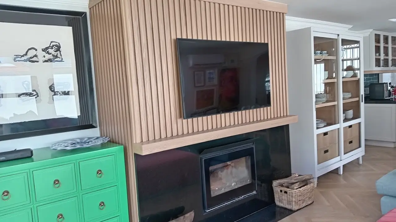 Oak-slat TV feature wall with fireplace and display cabinets