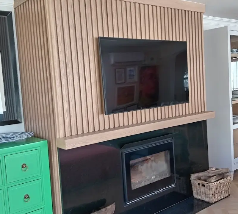 Oak-slat TV feature wall with fireplace and display cabinets
