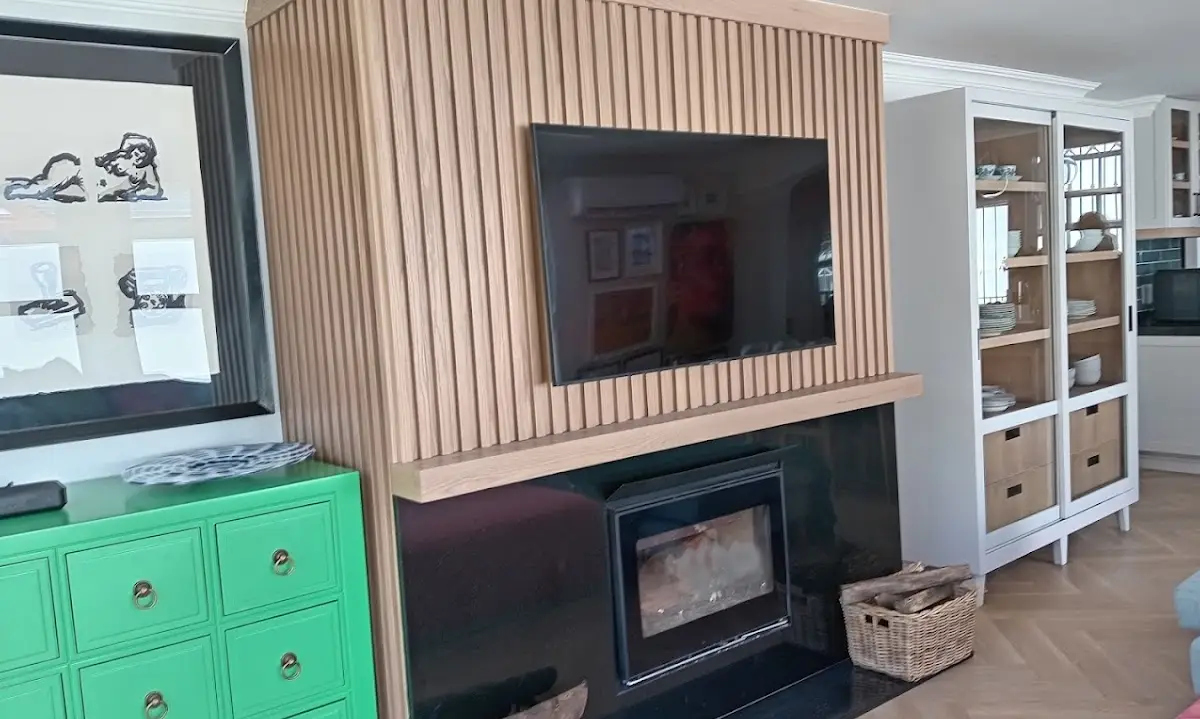 Oak-slat TV feature wall with fireplace and display cabinets